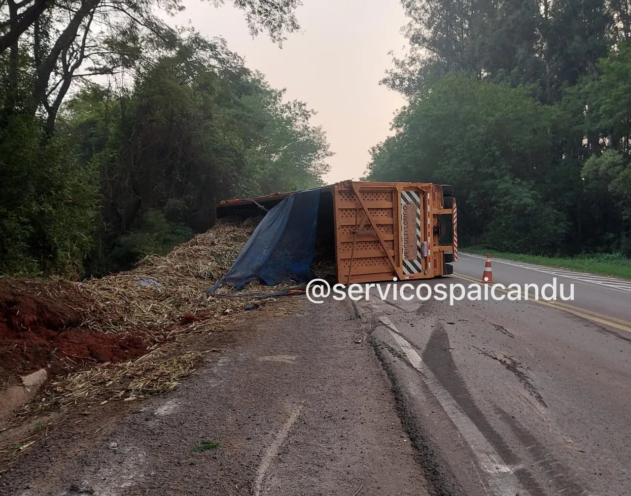 Motorista é socorrido após caminhão carregado com cana-de-açúcar tombar na PR-323
