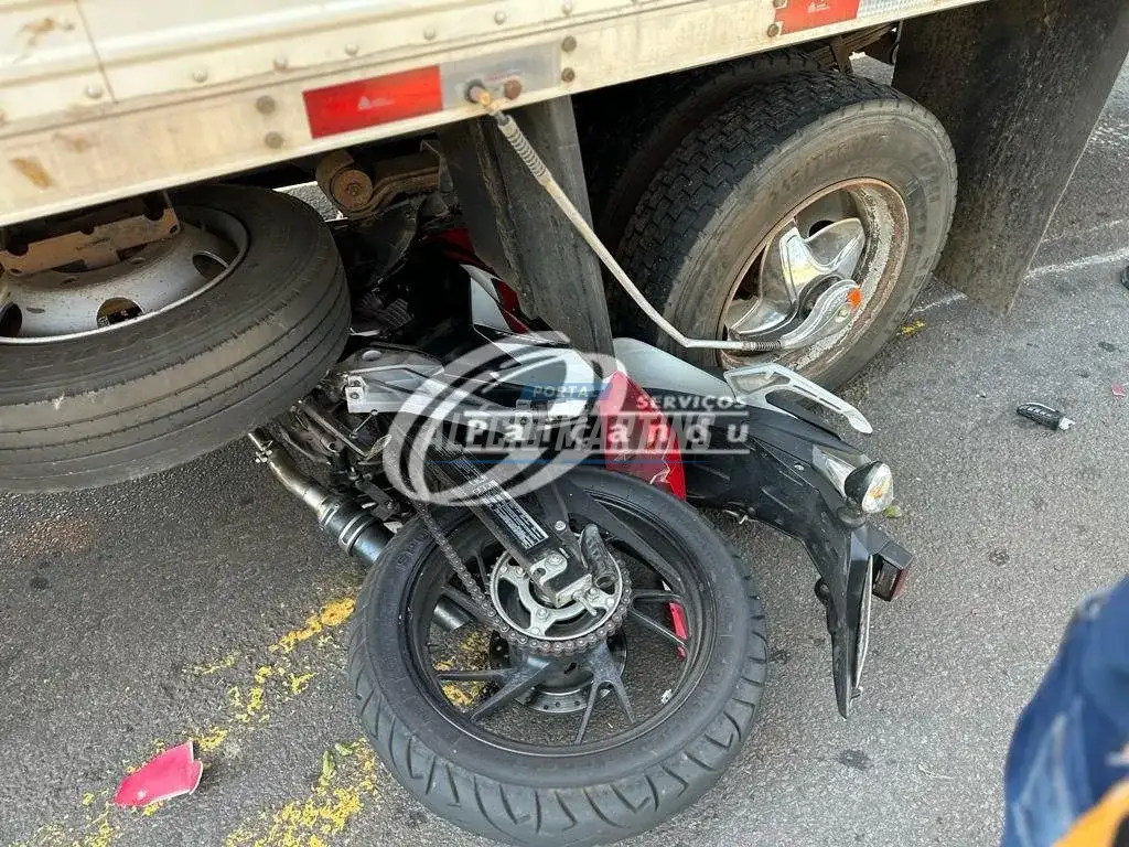 Moto vai parar embaixo de caminhão após acidente em Maringá. Motociclista foi socorrido com fratura exposta